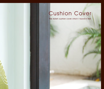 グリーンを基調としたクッションカバーは表面のオレンジとグリーンのお花の刺繍が特徴的。