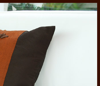 深い色合いのクッションカバーは表の中央にアジアンな装飾が3つならんでいてアクセントになっています。