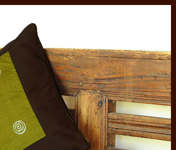 グリーンを基調としたクッションカバーは表面の異なる色の渦巻きの刺繍が特徴的。