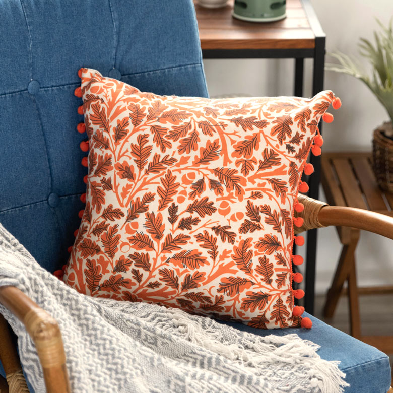 リーフ柄のポンポンつきクッションカバー。