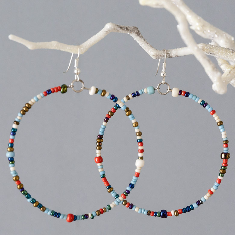 耳元で軽やかに揺れるカラフルなフープピアス