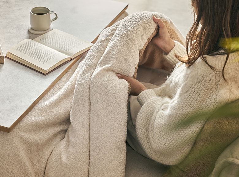 ブークレ素材のふわもここたつ布団に女性が入っている様子 中綿たっぷり 保温性イメージ