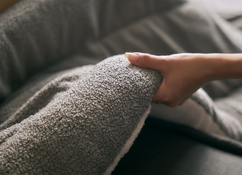 触れるたびに癒される、ぽこぽことした立体感のあるブークレ生地に触れている様子