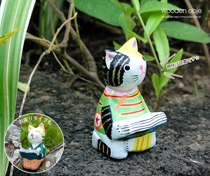 ちょこんとお座りして本を読んでいるバリネコのオブジェ。