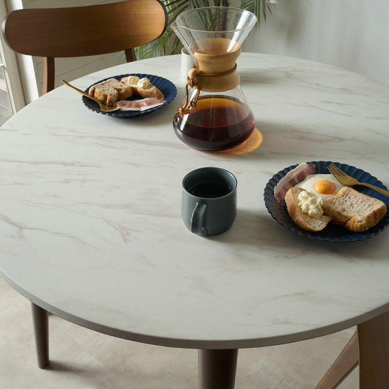 傷や汚れに強い新素材を使用した大理石調天板と、無垢材の脚で仕上げた