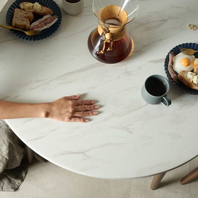 傷や汚れに強い新素材を使用した大理石調天板と、無垢材の脚で仕上げた